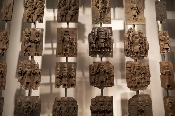 Seinällä on rivejä messinkilaattoja, joissa on erilaisia ​​hahmoja