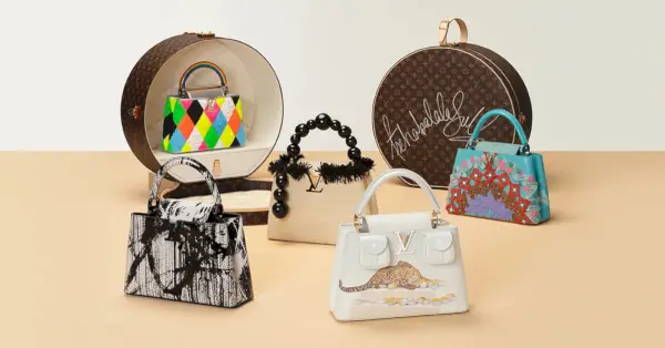 Hauskoilla ja muhkeilla kuvioilla varustetut käsilaukut istuvat pöydällä monogrammilla hattulaatikoilla