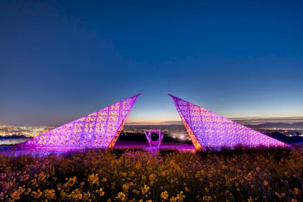 Kanciasta drewniana rzeźba na polu oświetlonym od wewnątrz nocą