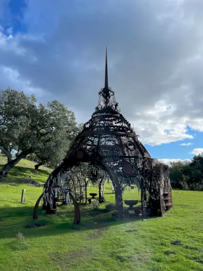 Rzeźba przypominająca świątynię na trawiastym polu