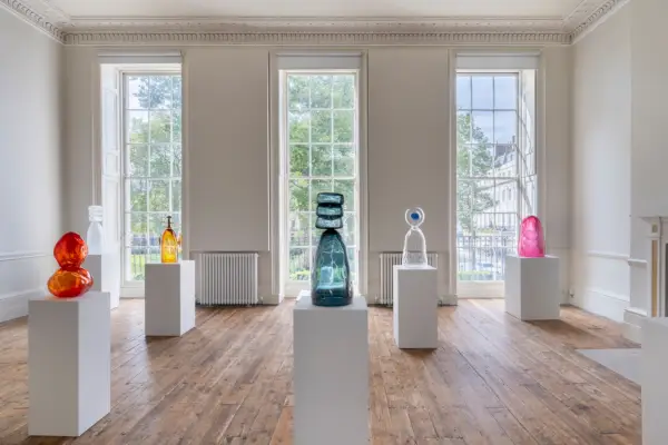 Skulpturer på fyrkantiga socklar i en konsthall med stora fönster