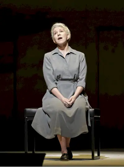 Mekossa istuva nainen laulaa lavalla