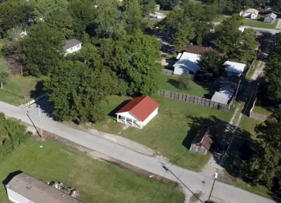 Drone laukaus pienestä talosta, joka sijaitsee suurella tontilla