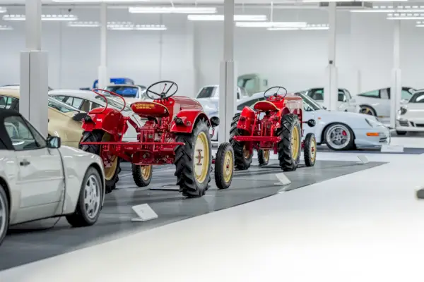 Dwa czerwone ciągniki w rzędzie białych samochodów sportowych