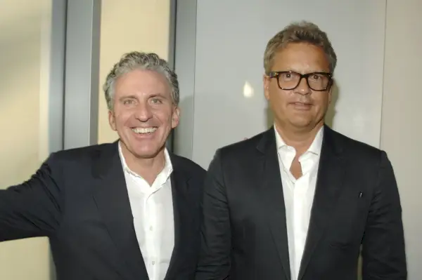 Due uomini con i capelli grigi vestiti con abiti neri