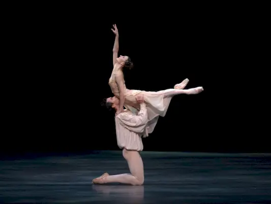 Miesbalettitanssija nostaa naisbalettitanssijan ilmaan