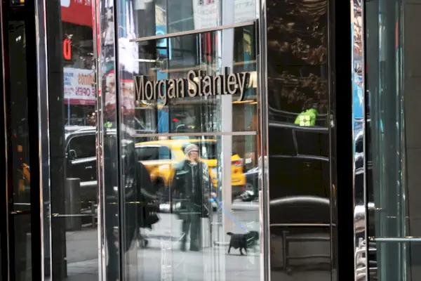 Ingresso alla sede centrale di Morgan Stanley, le porte riflettenti mostrano il cane che cammina nei passanti