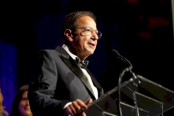 John Paulson parla al podi, vestit de vestit.