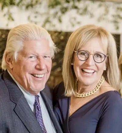 Mies ja nainen pukeutuneena pukuun ja laivastonsiniseen mekkoon