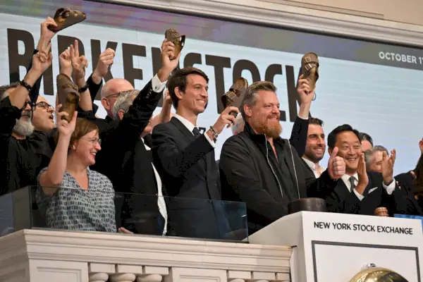 Parrakas mies, jota ympäröivät muut miehet, jotka pukeutuvat sandaaleihin