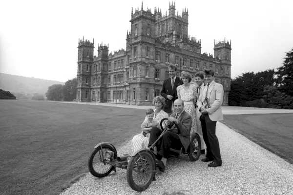 Lordi Carnarvon (oikealla) ja hänen isänsä Henry Carnarvon, Carnarvonin seitsemäs Earl (keskellä), istuvat 1922 Red Bug Buckboard -perheessä noin 1980.