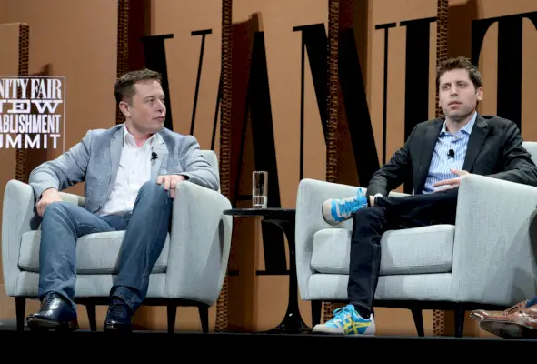 Dwóch mężczyzn w marynarkach siedzi na szarych kanapach na panelu