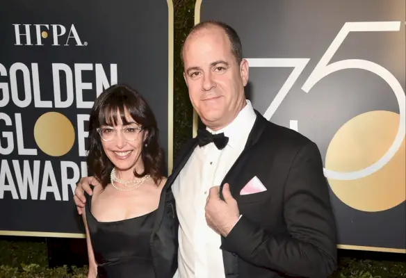 David Nevins ma na sobie garnitur na czerwonym dywanie, stojąc obok Andrei Blaugrund Nevins.