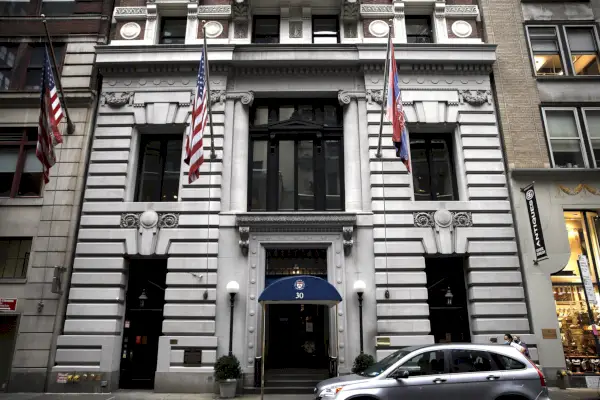 Suuri valkoinen rakennus, jossa liput riippuvat.