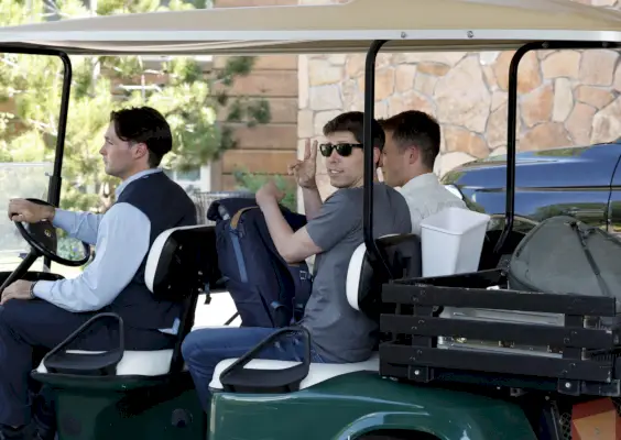 Mies harmaassa paidassa ajamassa pois golfkärryillä