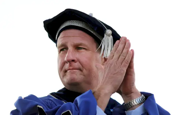 L'uomo con cappello e abito da laurea unisce le mani