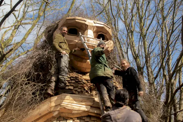Le persone lavorano alla costruzione di una gigantesca statua di troll in legno