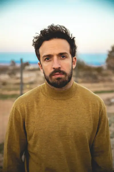 Pięciu mężczyzn stoi wokół stołu z dużym ciastem.