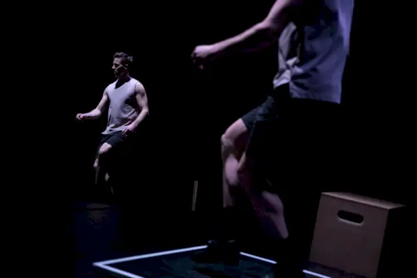 Dois dançarinos fazem uma dança no escuro