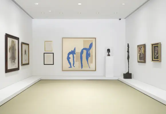 Scatto dell'interno della galleria, opere d'arte appese su tre pareti bianche