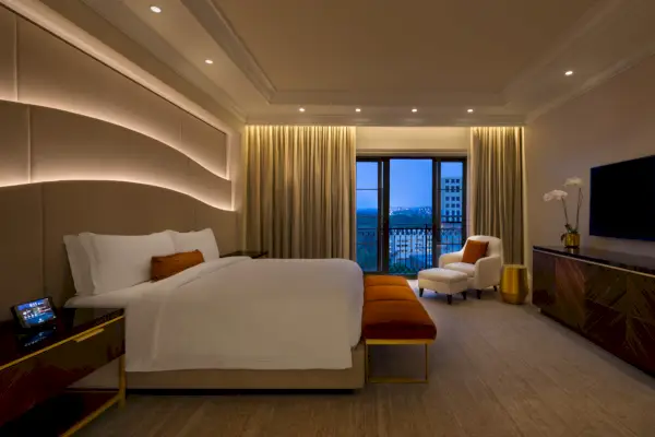 St. Regis Atlantan presidenttisviitin makuuhuone, jossa on sänky, tv ja terassi.