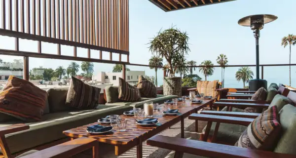 Un ristorante elegante con soffitto a baldacchino, lampadari a braccio e grandi finestre.