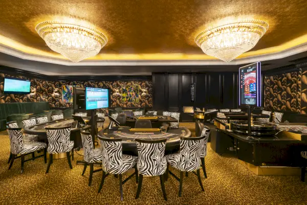 Privé Tables Sun City Casinolla seeprakuvioisilla tuoleilla ja suurilla valaisimilla.