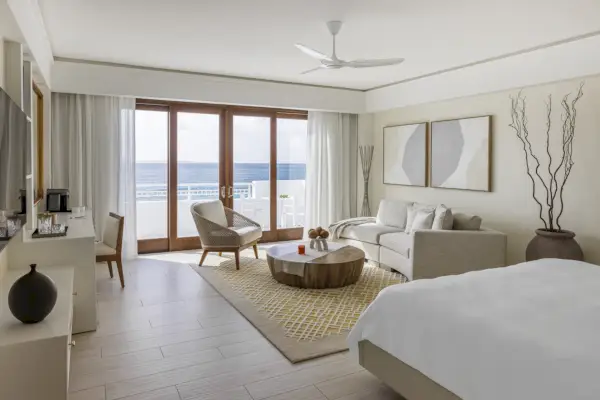 rantasviitti hotellissa Anguillassa, jossa on sänky, tuolit ja sohva veteen päin .