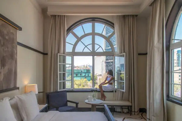 Hotellihuone, jossa on suuri ikkuna näköalalla kaupunkiin