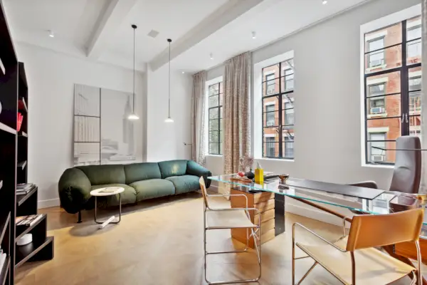 Moderni olohuone, jossa on vaaleat puulattiat ja korkea katto.