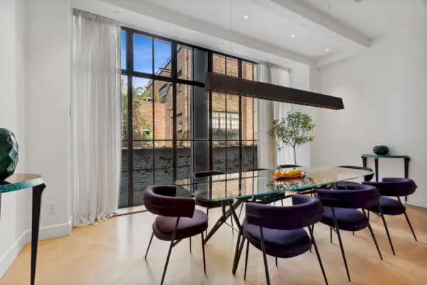 Moderni ruokasali, jossa on valkoiset verhot ja violetit samettituolit.