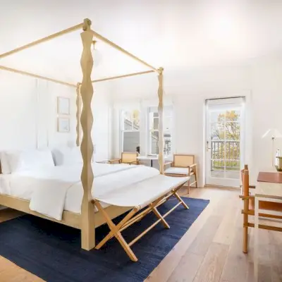 The Lake Housen vierashuone, jossa on pylvässänky vasemmalla ja ikkunat ja ovi taustalla.