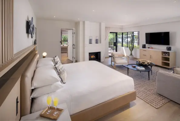 mökki, jossa on valkoinen sänky ja olohuone.