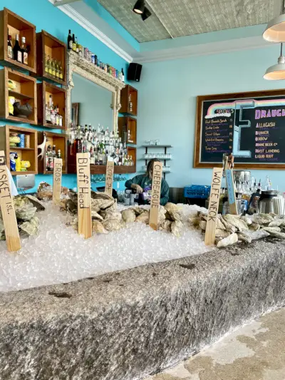 Sinivihreä osteribaari, jossa on kalaa jäässä.