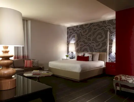 Hotellihuone, jossa on punaisia ​​ja harmaita aksentteja.