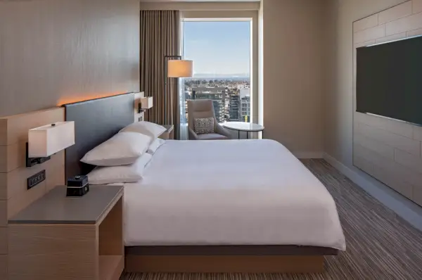 Tyylikäs hotellihuone, jossa on valkoinen sänky ja kaupunkinäköala