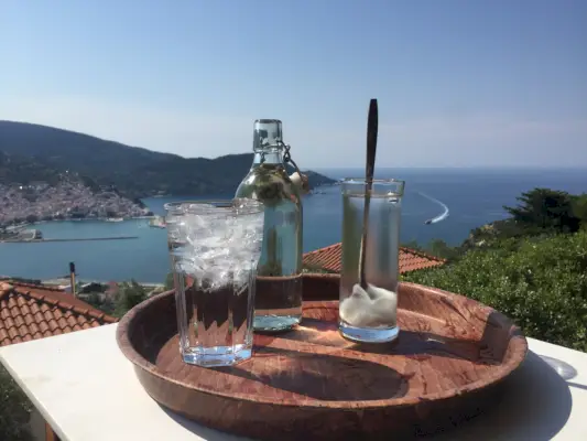 tre glas på en träbricka framför Egeiska havet i Grekland