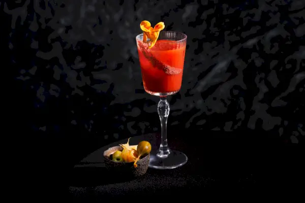 en röd cocktail i ett glas med skaft