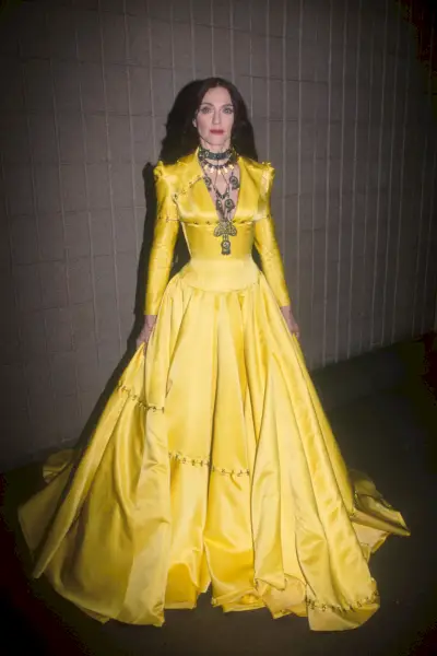 Madonna amb un cosset ajustat amb un vestit groc de faldilla completa