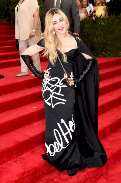 Madonna amb un vestit negre estampat amb capa i guants