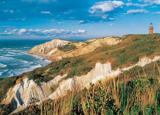 Un piccolo faro si trova in cima alle scogliere in riva al mare