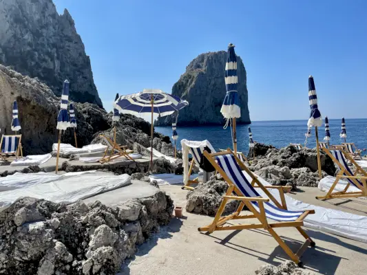 Rantatuoli merinäköalalla ja sateenvarjot