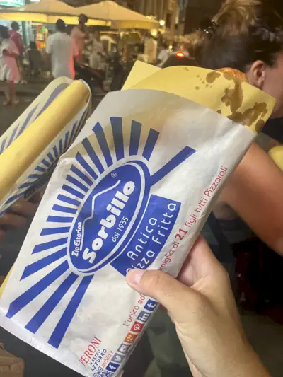 kädessä paistettu pizza