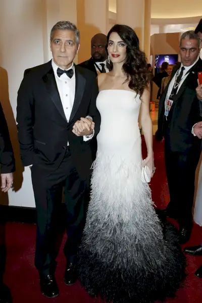 Clooney klädd i en vit fjäderklänning