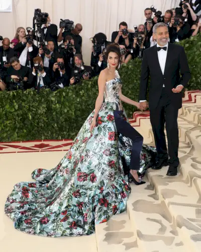 Clooney klädd i en blommig tågklänning med byxor och metalliskt livstycke