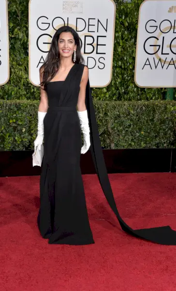 Clooney klädd i en svart draperingrock med vita handskar