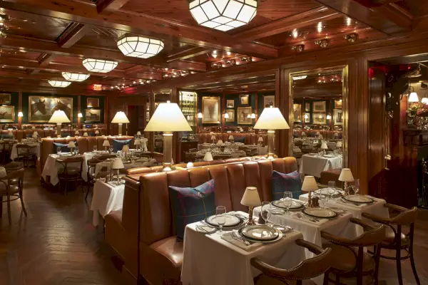 accogliente ristorante con pannelli in legno, divanetti in pelle e cuscini scozzesi