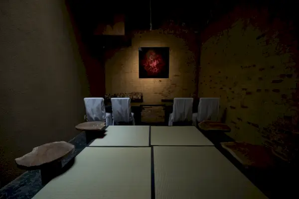 Interno della stanza molto poco illuminato e scarsamente decorato con sedie