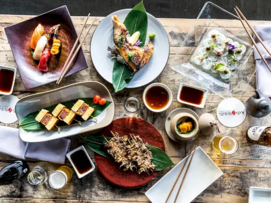 Iso pöytä täynnä sushia ja muuta ruokaa.