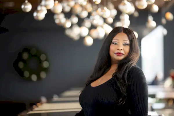 Nainen mustaan ​​toppiin seisoo unenomaisten valojen edessä